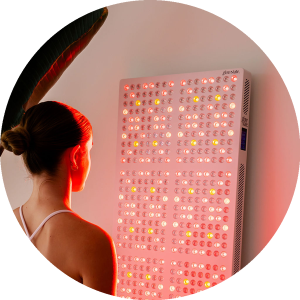 The Radiance960 full body red light panel being used by a lady in bedroom with the LEDs glowing on her body, close up image.