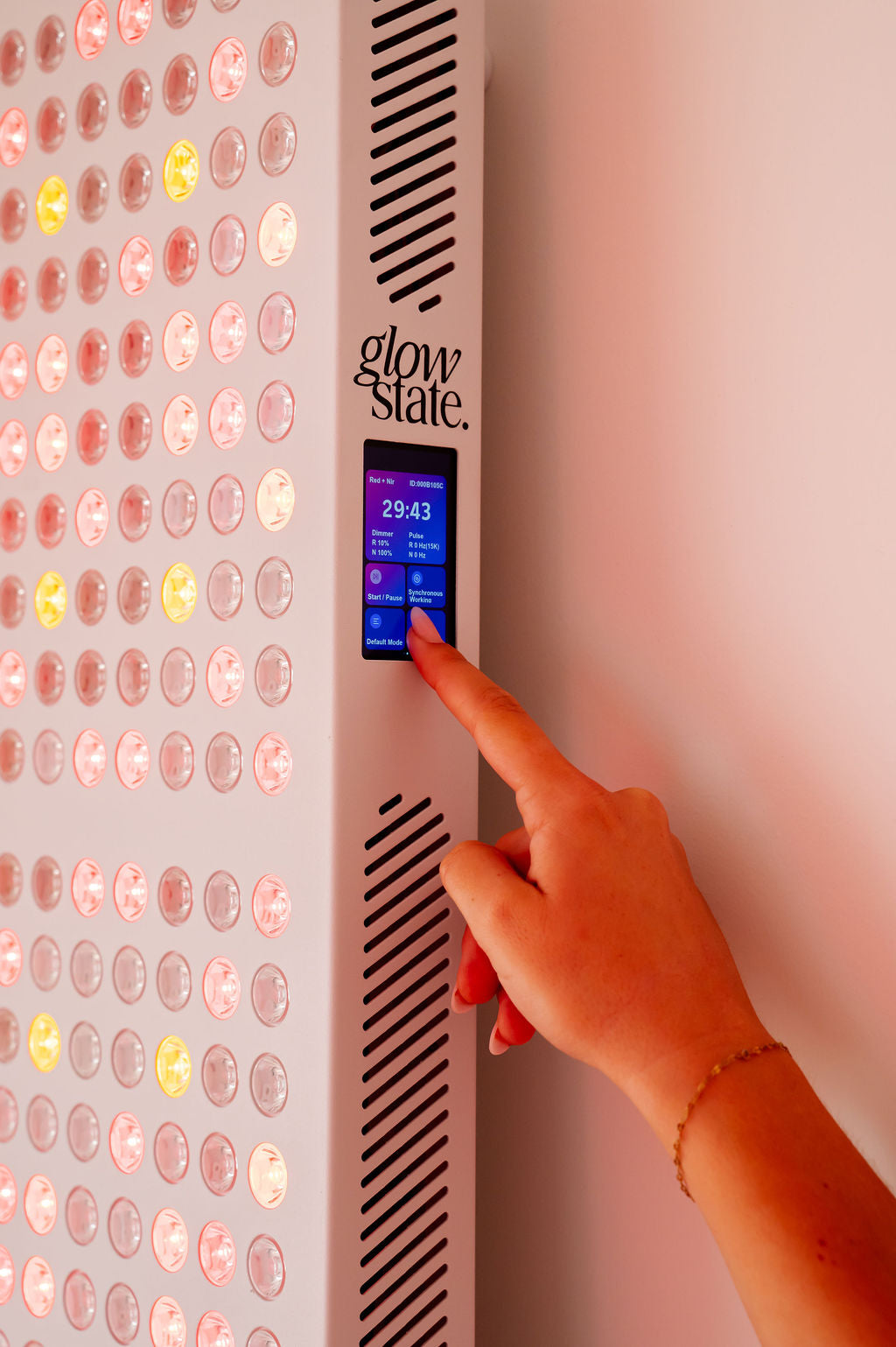 The Radiance960 full body red light panel touchscreen used by a lady, the glowing LEDs shine.