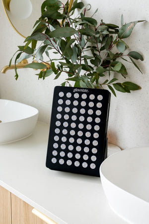 Radiance60 red light panel has a black frame and is sitting on the bathroom benchtop