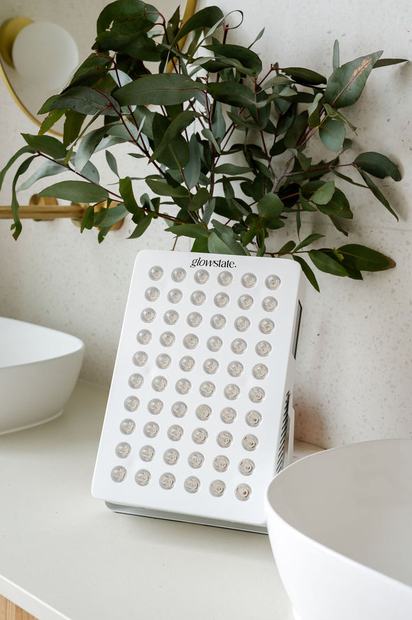 Radiance60 red light panel has a white frame and is sitting on the bathroom benchtop