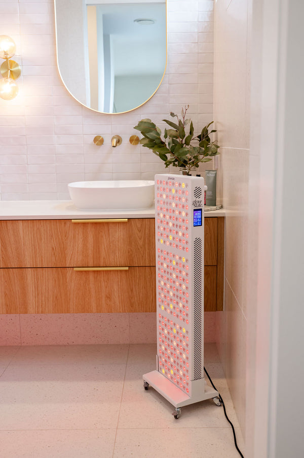 The Radiance300 red light panel in bathroom on a mobile stand, the LEDs are shining and touch screen illuminated.