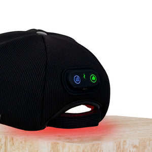 The Halo red light therapy cap sitting on a plinth showing the control panel in zero pulse mode, mid power, LEDs glowing.