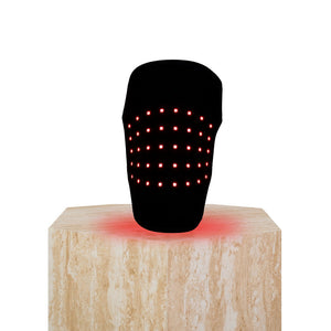 The Focus Flex Joint Wrap, a flexible red light therapy joint wrap, on a plinth showing the back view and LEDs glowing.